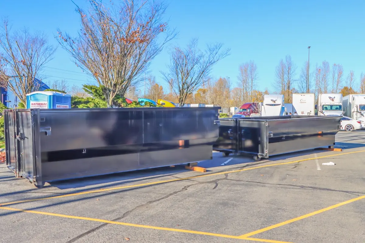 Professional dumpster rental service with roll-off container on residential driveway in Gates